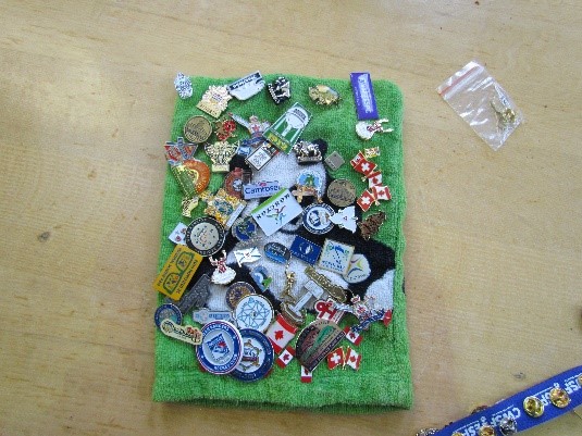 Pins for Trade at CWSF on a Green cloth for display. 